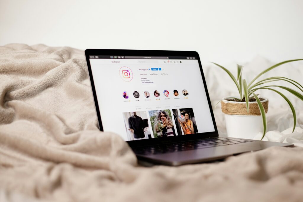 Instagram page open on a laptop displaying influencer posts with product promotions.