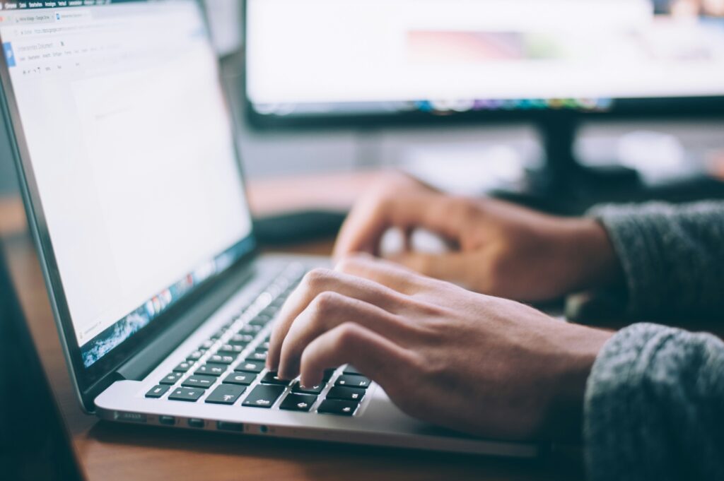 A person typing a blog on a laptop, focused on creating engaging content.