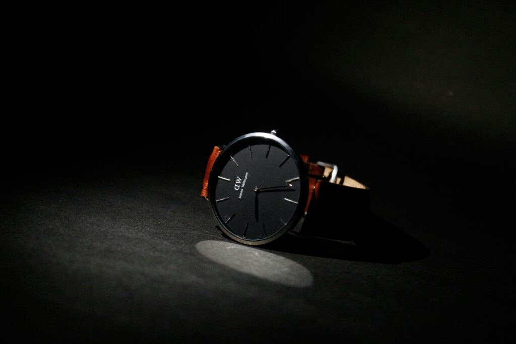 A stylish Daniel Wellington watch displayed on a sleek black background, highlighting its minimalist design and elegance, showcasing the effectiveness of influencer marketing in promoting luxury timepieces.