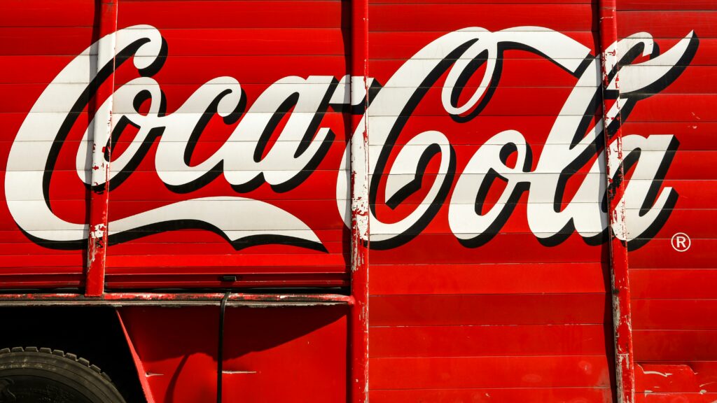 The Coca-Cola logo featuring the iconic cursive script in red and white, symbolizing tradition and energy in branding.