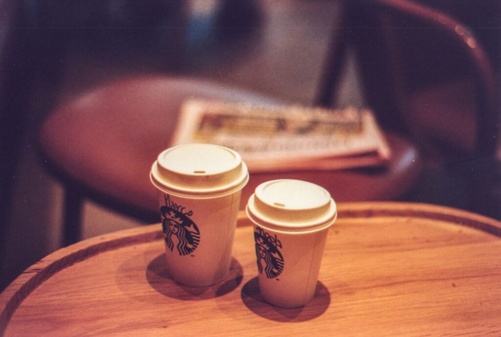 Two Starbucks cups placed on a table.