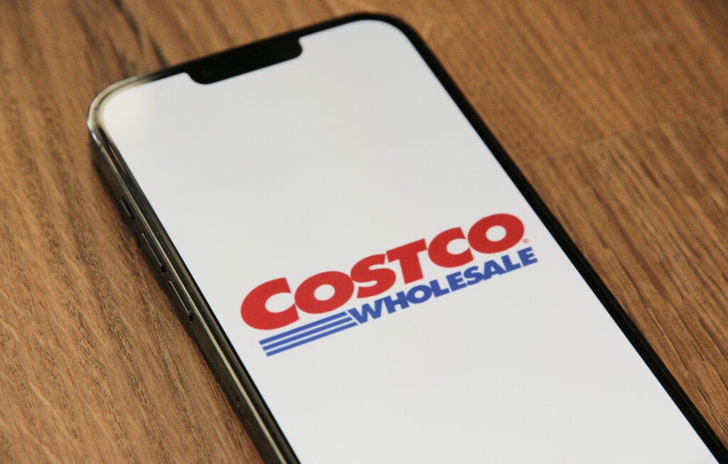 A smartphone displaying the Costco Wholesale logo, symbolizing the brand's digital presence and customer engagement strategies.