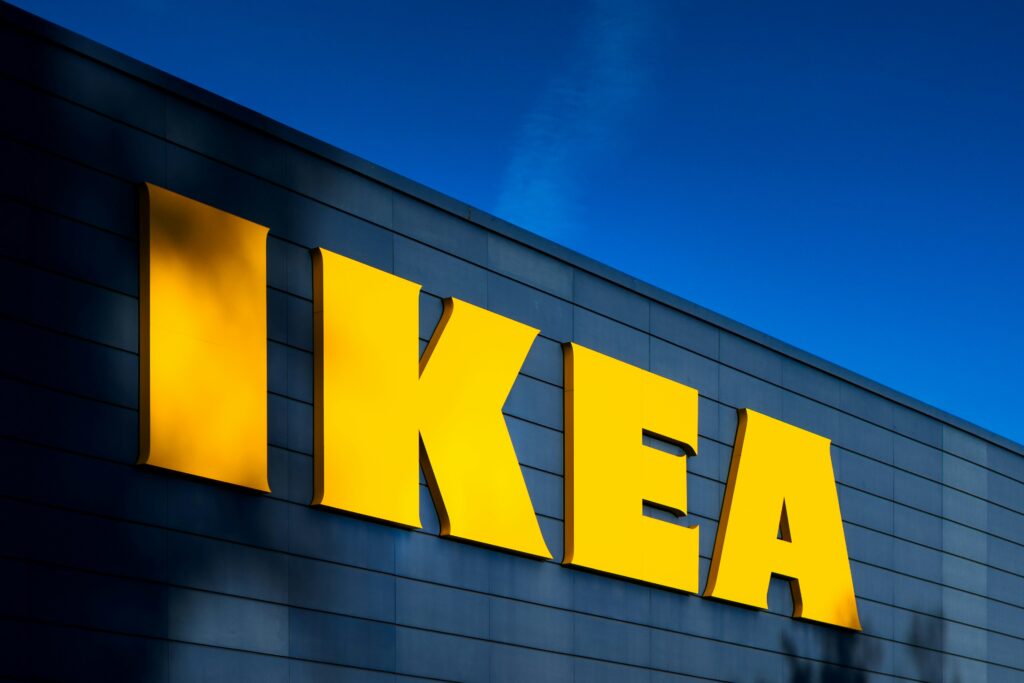 IKEA logo displayed on a blue wall, emphasizing the brand's iconic colors and identity.