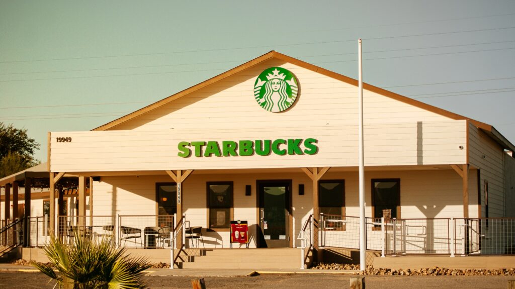 Exterior view of a Starbucks store, showcasing its inviting atmosphere and branding in a bustling urban setting, using geomarketing to attract customers.