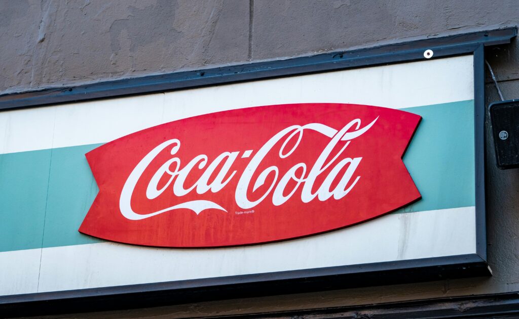 Coca-Cola logo displayed on a banner, illustrating the brand's timelessness, brand symbol and enduring appeal in the beverage industry.