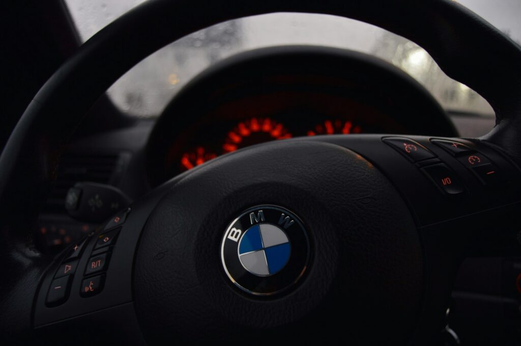 Close-up of a BMW steering wheel, showcasing the luxury and craftsmanship that defines the brand's voice.