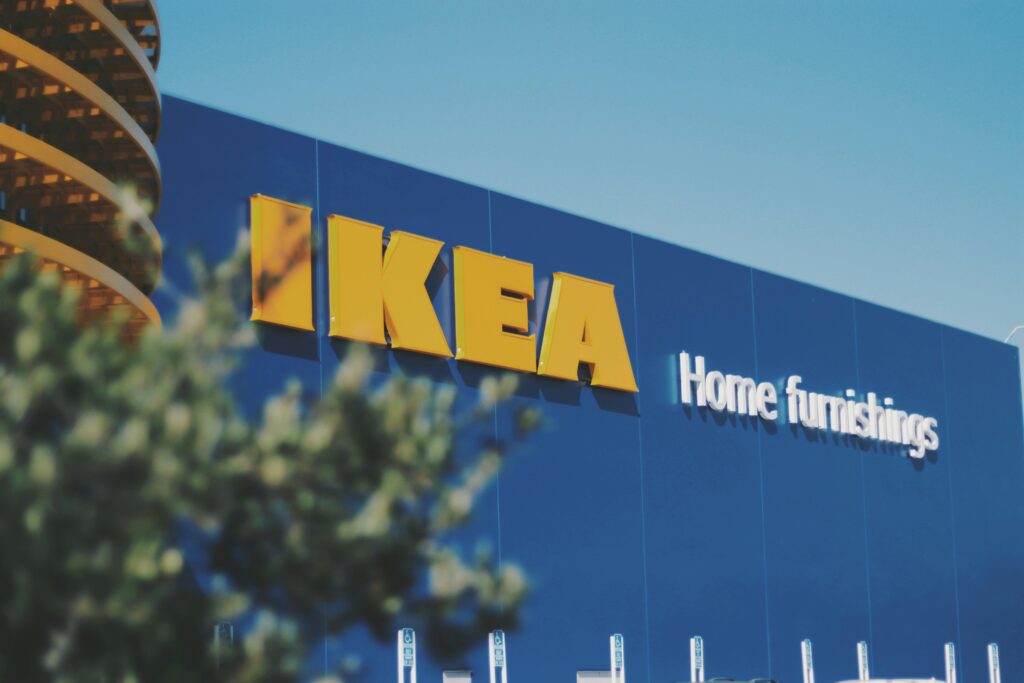 IKEA logo on a blue wall with the words "Home Furnishing" displayed underneath, they use AR to improve shopping experience through mobile marketing.