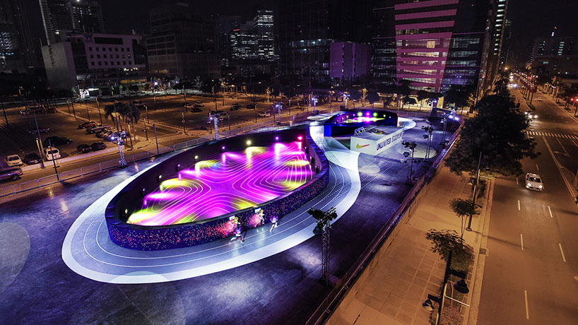 Nike's Unlimited Stadium in Manila, showcasing the world's first full-sized LED running track as part of experiential marketing. The innovative pop-up arena features a 200-meter figure-eight track lined with vibrant LED screens, allowing participants to run alongside virtual avatars of themselves.