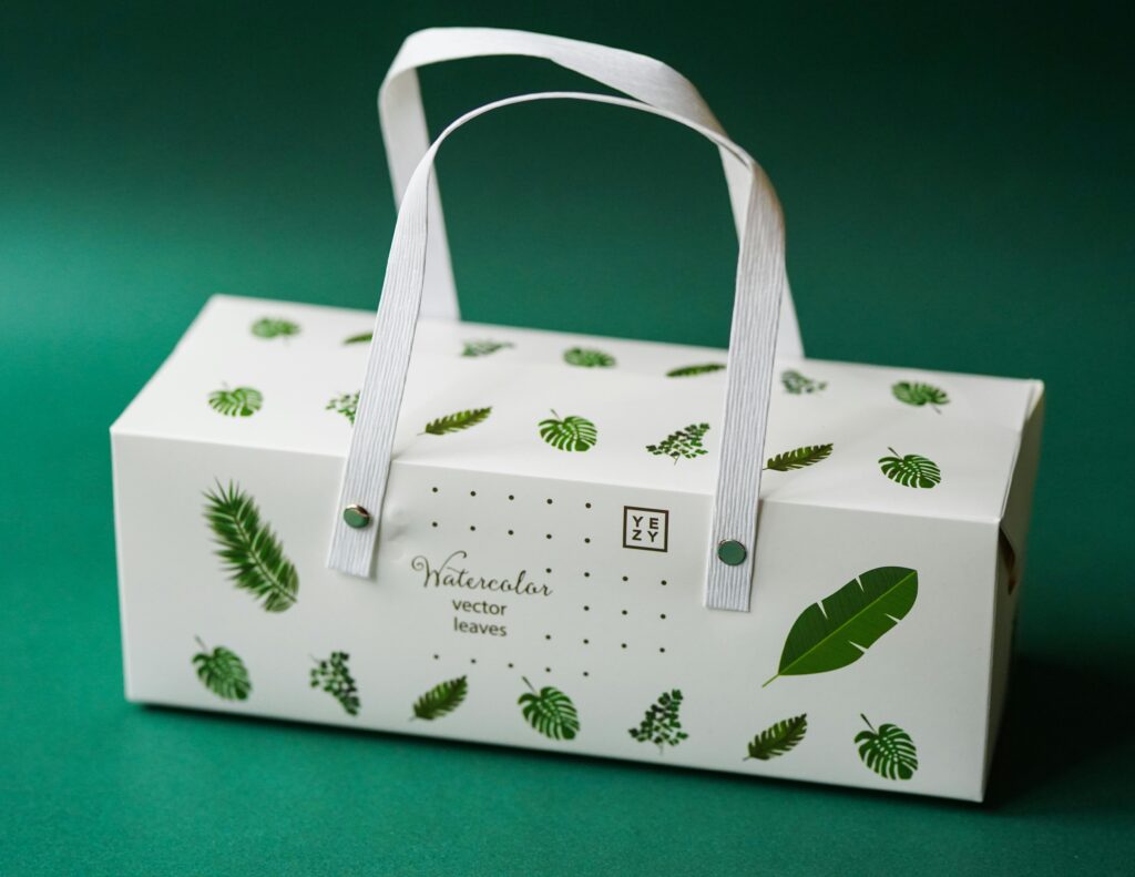 A white packaging featuring green leaf prints, symbolizing sustainable branding and eco-friendly practices in product packaging.