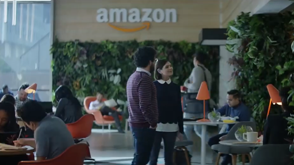 Two people standing in front of the Amazon logo, smiling and posing, from the "Not Everything Makes the Cut" ad.