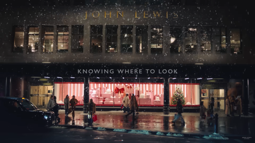 Two girls joyfully meet outside a John Lewis store, showcasing the power of storytelling marketing through their emotional reunion.