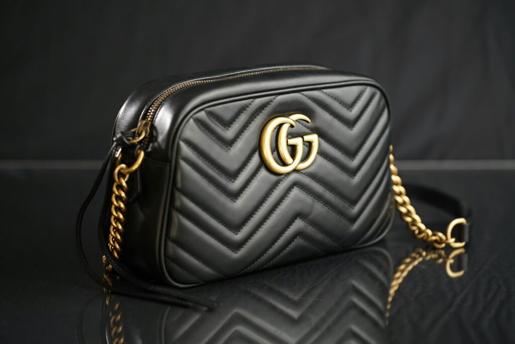 A stylish Gucci bag featuring the iconic GG logo, elegantly displayed against a neutral background, showing the Monochromatic Color Schemes. 