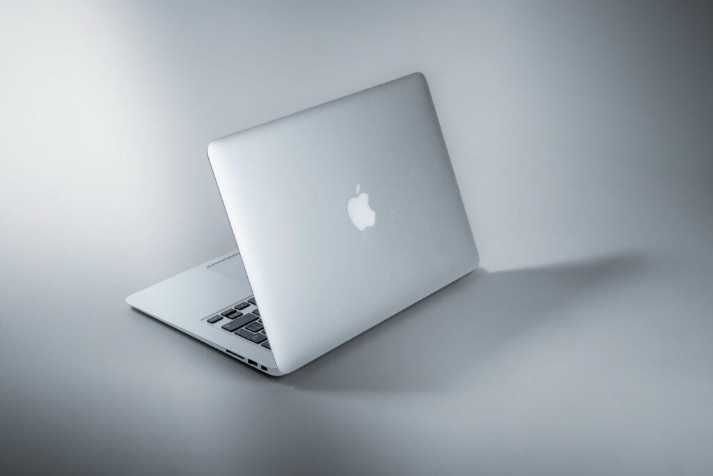 A sleek Apple MacBook resting on a wooden table, showcasing its minimalist design and modern aesthetic.